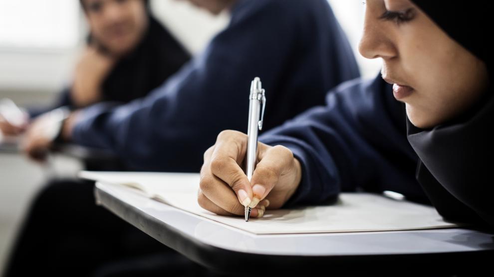 Girl in classroom writing in notebook